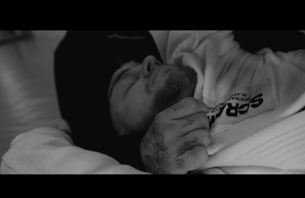 A photographic still from the short film Run Deep. The photo shows a man in a jiu jitsu hold during practise.