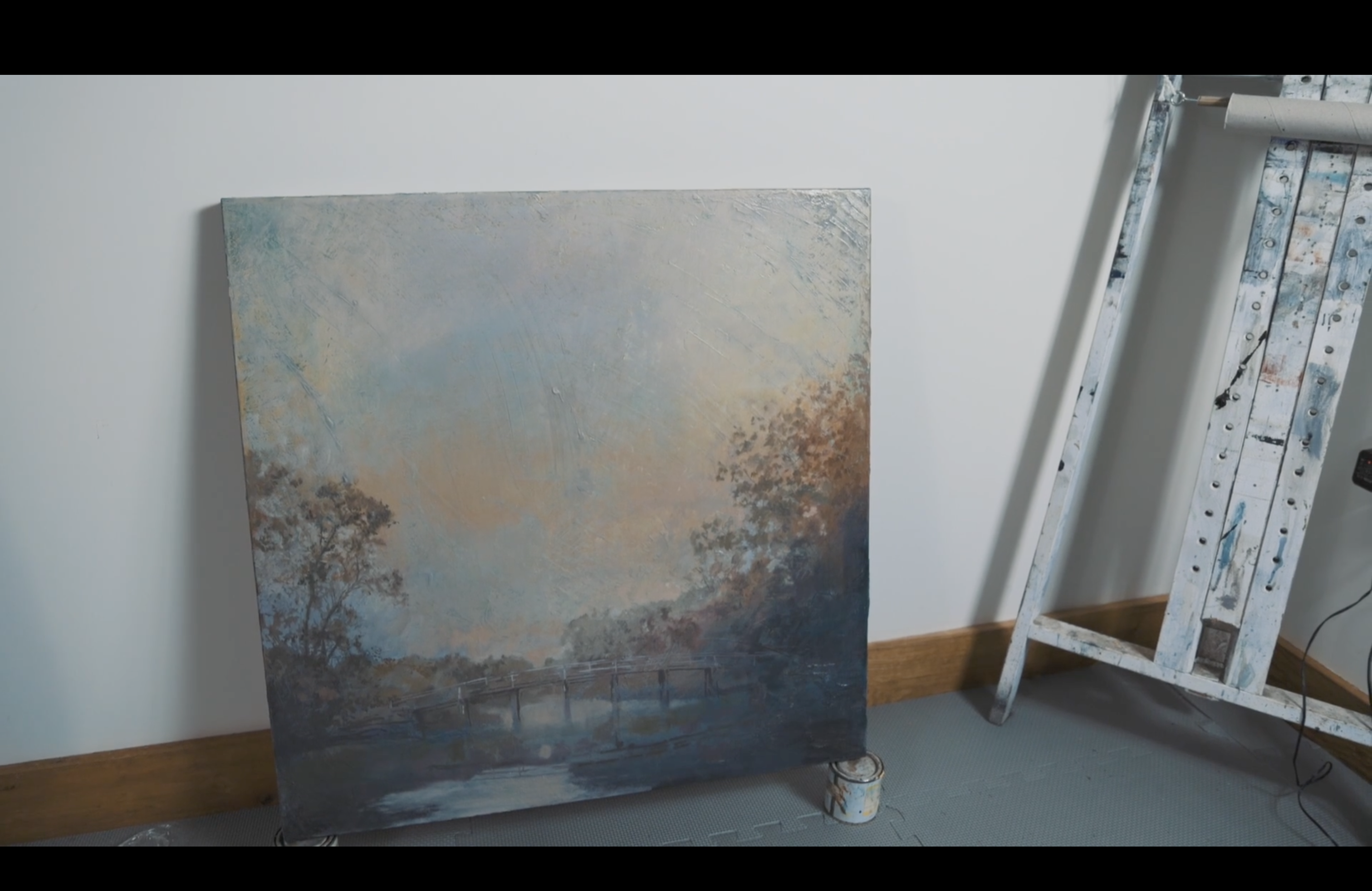 A photographic still from the short film The Artist. The photo shows a large canvas of an oil painting.